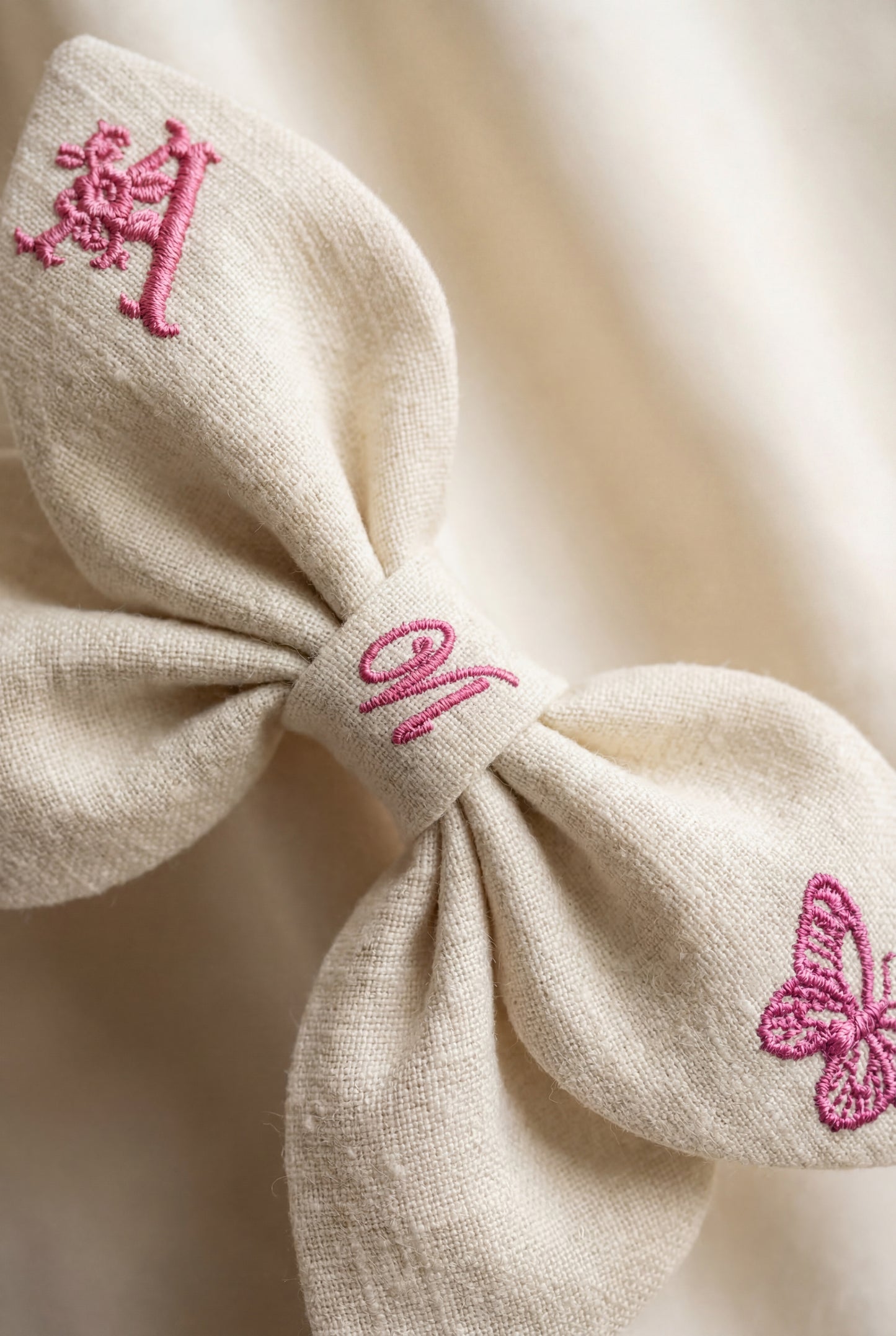 Leinenschleife mit Schmetterlingsstickerei und Monogramm A, B, C ... Z. Frühling 